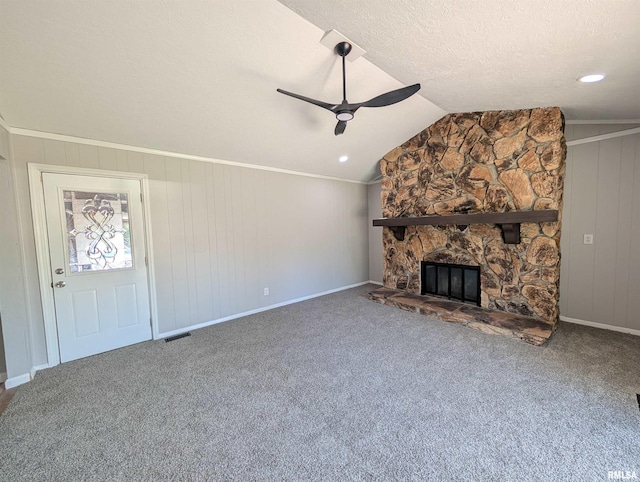 unfurnished living room featuring a ceiling fan, a fireplace, vaulted ceiling, carpet, and baseboards