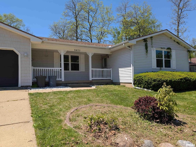 ranch-style home with covered porch, a garage, and a front yard