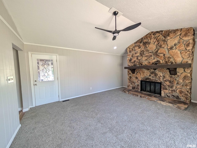 unfurnished living room featuring ceiling fan, a stone fireplace, lofted ceiling, baseboards, and carpet floors