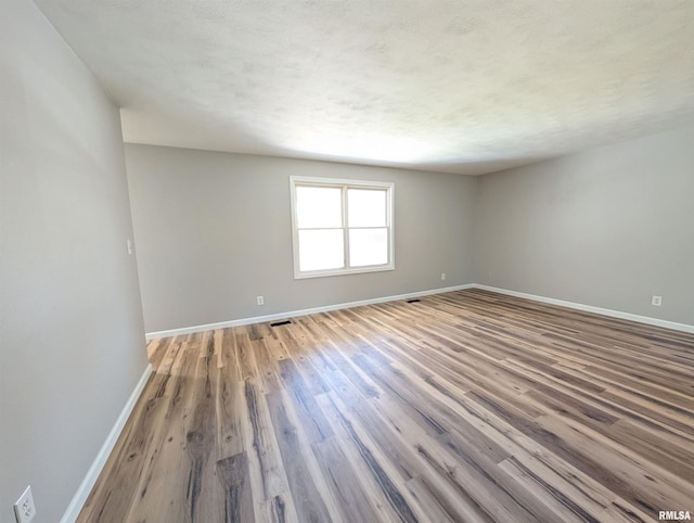 empty room featuring baseboards and wood finished floors