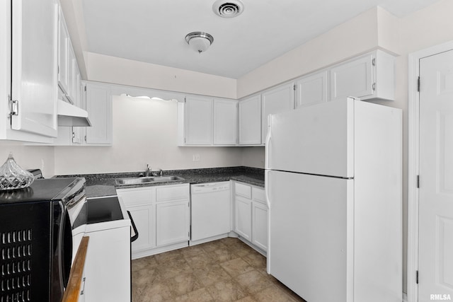 kitchen featuring white appliances, dark countertops, a sink, and white cabinets