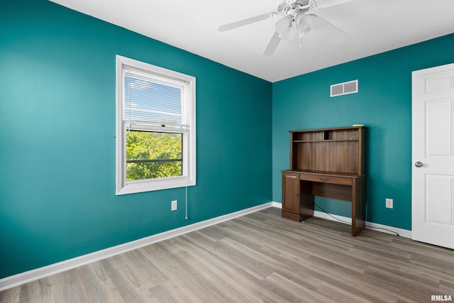 unfurnished bedroom with wood finished floors, baseboards, and a ceiling fan