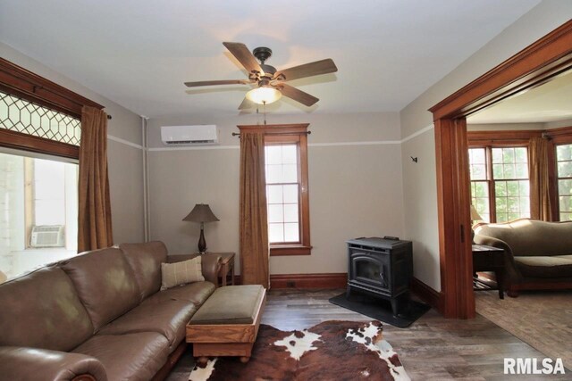 102 2nd St, Camp Grove, IL 61424 - living area featuring a wall mounted AC, a wood stove, healthy amount of natural light, and wood finished floors