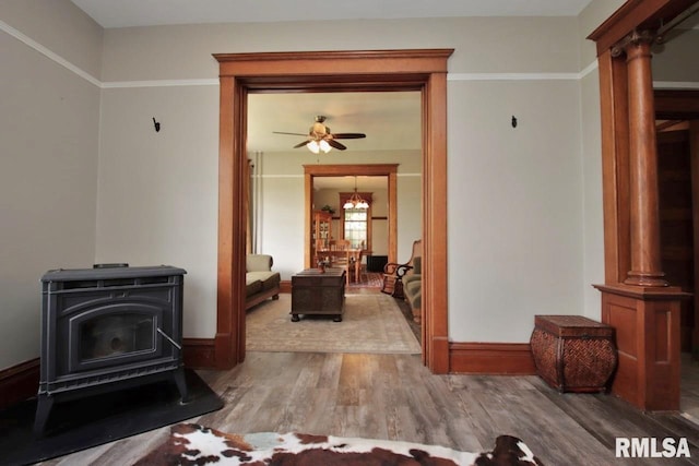102 2nd St, Camp Grove, IL 61424 - living area with a wood stove, wood finished floors, baseboards, and a ceiling fan
