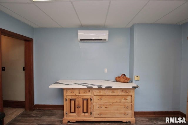 102 2nd St, Camp Grove, IL 61424 - bedroom featuring a wall mounted AC, dark wood-type flooring, baseboards, and a drop ceiling