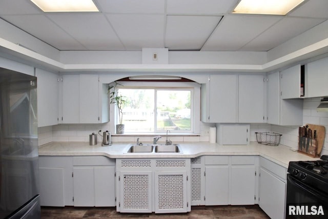 102 2nd St, Camp Grove, IL 61424 - kitchen with black range with gas stovetop, a sink, freestanding refrigerator, decorative backsplash, and a drop ceiling