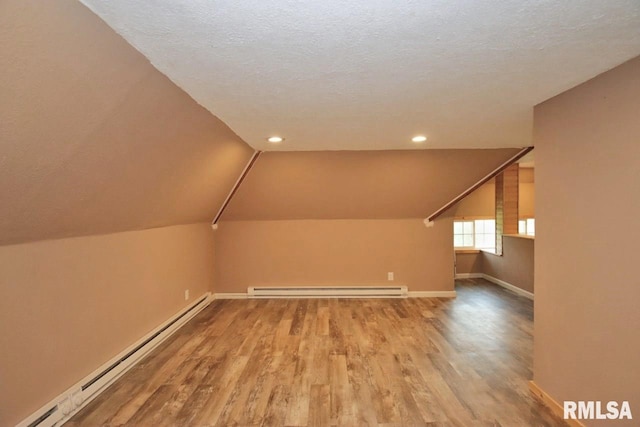 102 2nd St, Camp Grove, IL 61424 - additional living space featuring a baseboard radiator, baseboards, wood finished floors, vaulted ceiling, and a textured ceiling