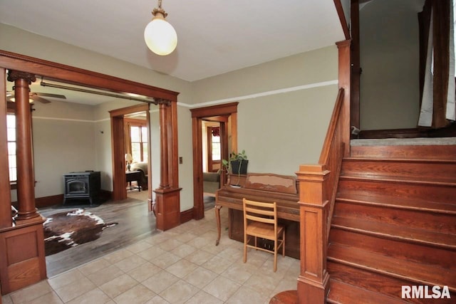 102 2nd St, Camp Grove, IL 61424 - entrance foyer with a wood stove, stairs, a ceiling fan, and baseboards