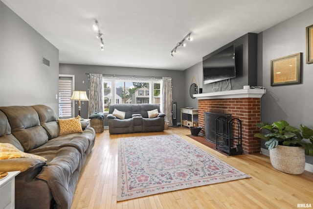 2220 W Ayres Ave, West Peoria, IL 61604 - living area with hardwood / wood-style flooring, track lighting, and a brick fireplace
