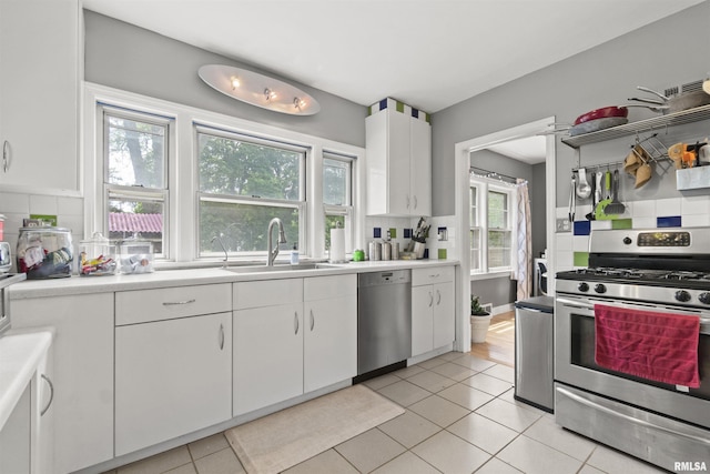 2220 W Ayres Ave, West Peoria, IL 61604 - kitchen with stainless steel appliances, a sink, light tile patterned floors, and light countertops