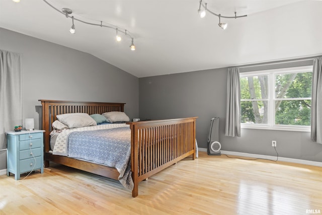 2220 W Ayres Ave, West Peoria, IL 61604 - bedroom with rail lighting, lofted ceiling, light wood-type flooring, and baseboards