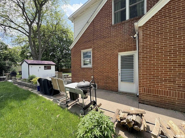 2220 W Ayres Ave, West Peoria, IL 61604 - back of property with a patio, brick siding, an outbuilding, and a lawn