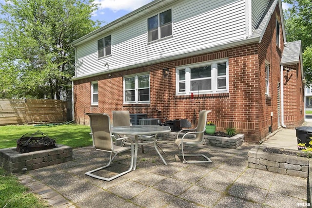 2220 W Ayres Ave, West Peoria, IL 61604 - back of house with an outdoor fire pit, brick siding, a patio, outdoor dining area, and fence