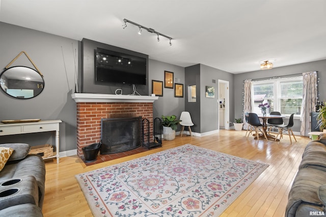 2220 W Ayres Ave, West Peoria, IL 61604 - living area featuring hardwood / wood-style floors, rail lighting, and a brick fireplace