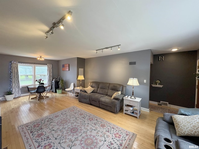 2220 W Ayres Ave, West Peoria, IL 61604 - living room with rail lighting, light wood-type flooring, and baseboards