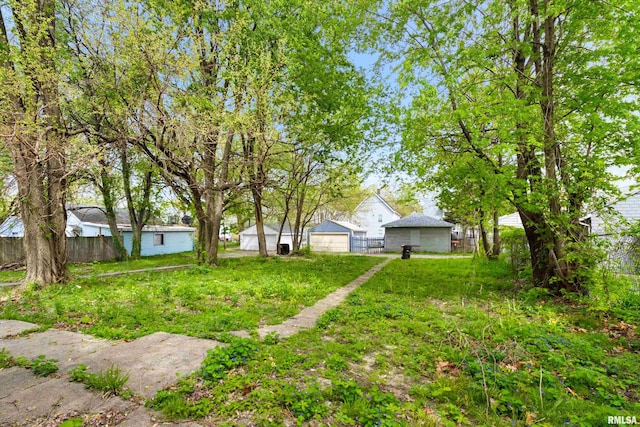 view of yard with a detached garage and fence