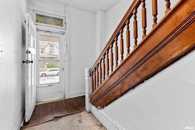 foyer with stairway and baseboards