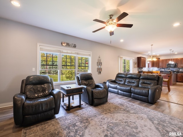 living area with plenty of natural light, a chandelier, ceiling fan, recessed lighting, and wood finished floors