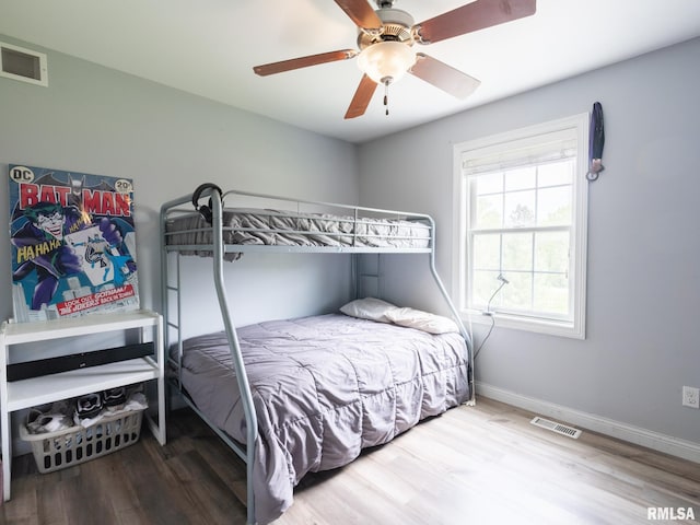 bedroom featuring wood finished floors, baseboards, and ceiling fan