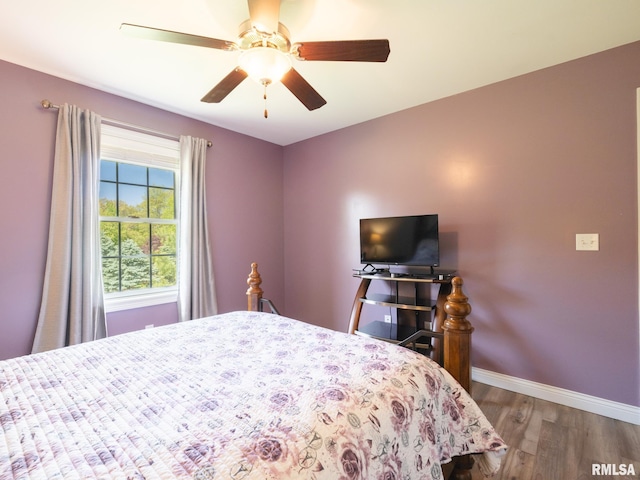 bedroom with wood finished floors, baseboards, and a ceiling fan