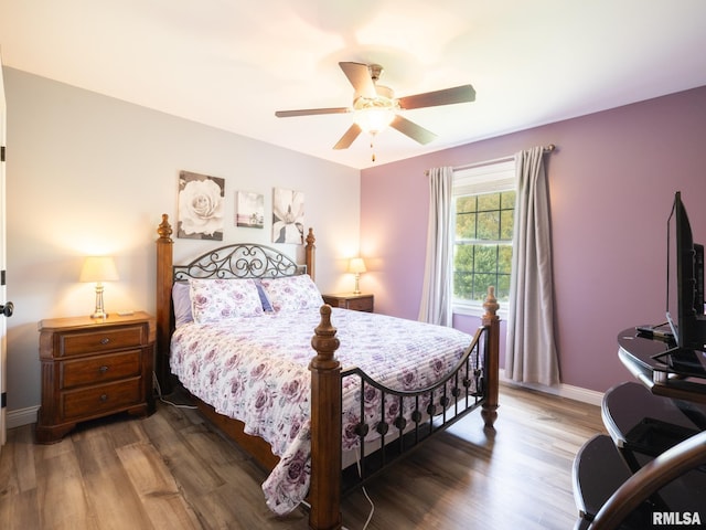 bedroom with wood finished floors, baseboards, and a ceiling fan