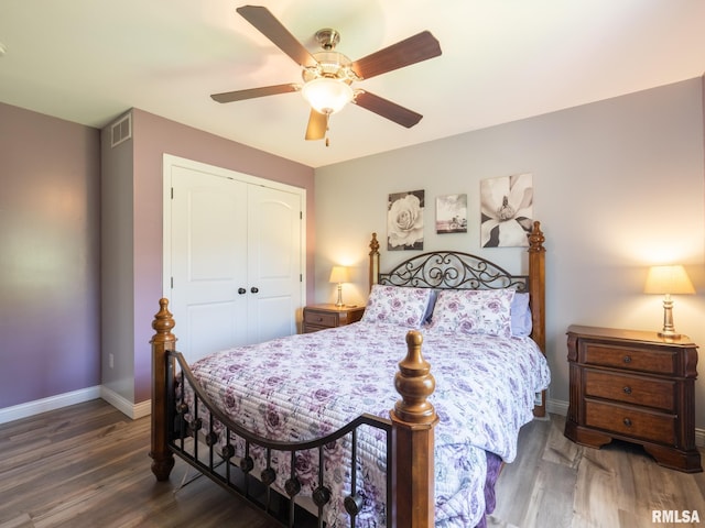 bedroom featuring a closet, wood finished floors, baseboards, and a ceiling fan