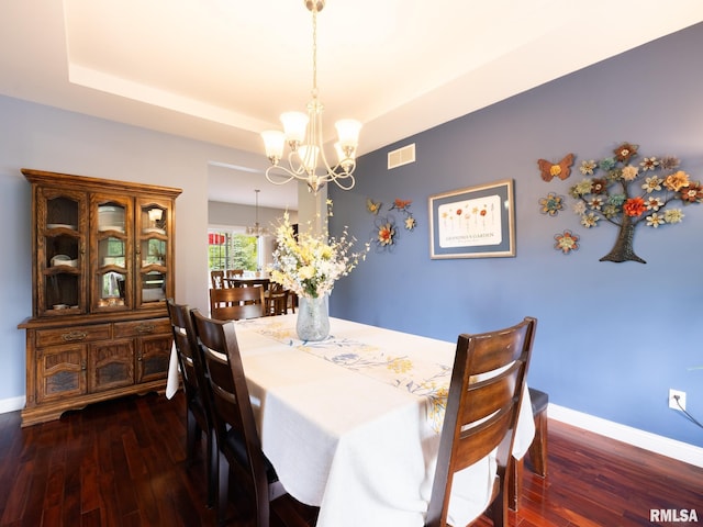 dining room with a chandelier, hardwood / wood-style flooring, and baseboards