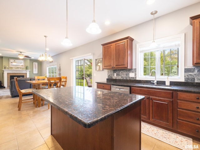 kitchen featuring a sink, light tile patterned floors, tasteful backsplash, dishwasher, and plenty of natural light