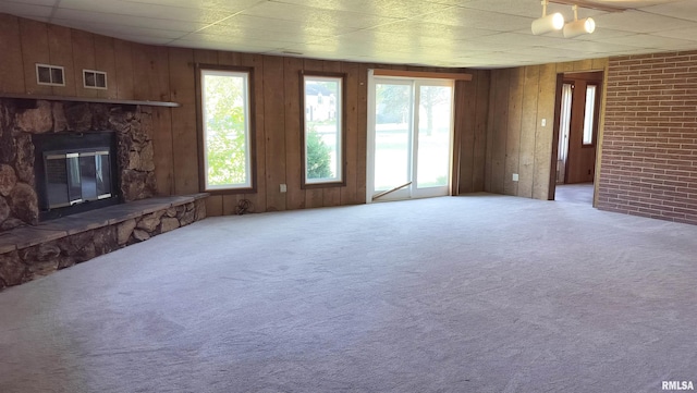 927 W Oakview Dr, Peoria, IL 61615 - unfurnished living room with carpet, a fireplace, and wood walls
