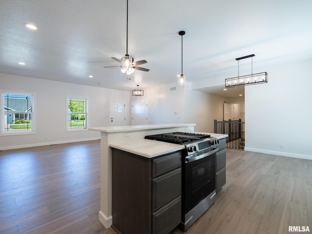 kitchen with gas range oven, light wood-style floors, open floor plan, ceiling fan, and recessed lighting