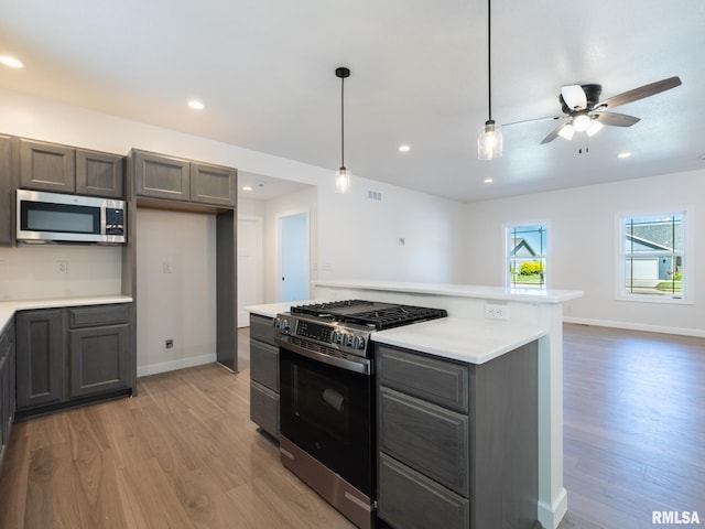 kitchen with appliances with stainless steel finishes, light wood-type flooring, ceiling fan, light countertops, and recessed lighting