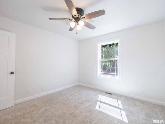 spare room with carpet, ceiling fan, and baseboards