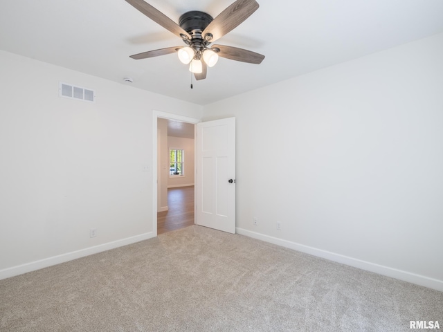 carpeted empty room with baseboards and a ceiling fan