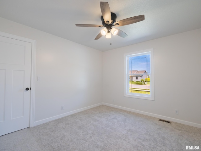 carpeted empty room with baseboards and ceiling fan