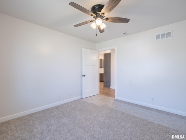 unfurnished room featuring light carpet, a ceiling fan, and baseboards