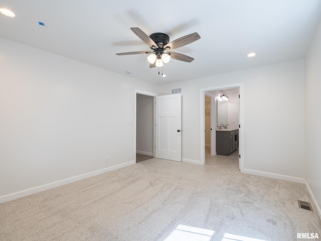 unfurnished bedroom featuring light carpet, baseboards, recessed lighting, and ensuite bath