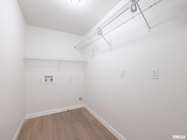 laundry area featuring light wood-style floors, baseboards, and hookup for a washing machine