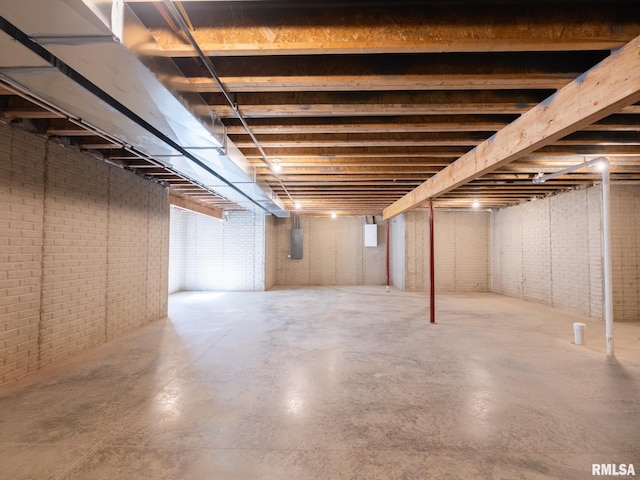 below grade area featuring brick wall and electric panel