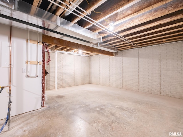 unfinished below grade area featuring brick wall