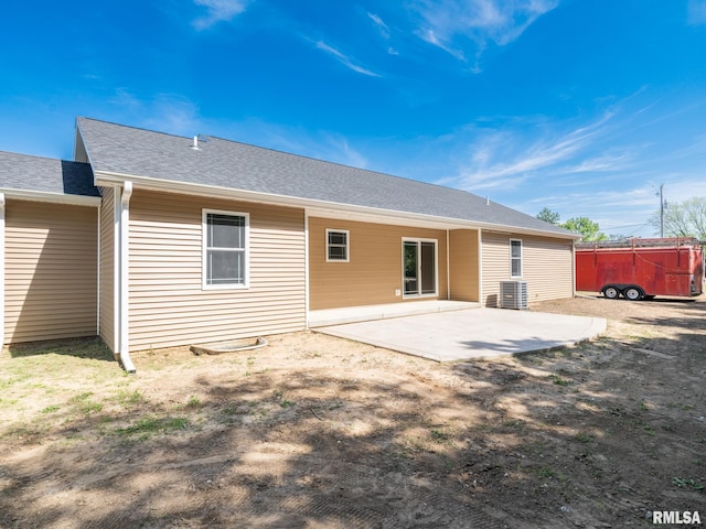 rear view of property featuring a patio, a shingled roof, and cooling unit