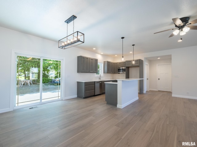 kitchen featuring stainless steel appliances, gray cabinetry, light wood-style floors, baseboards, and light countertops