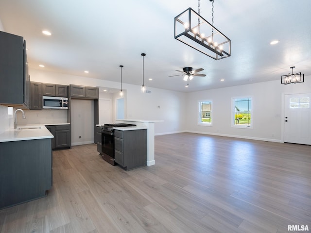 kitchen featuring stainless steel appliances, a sink, a chandelier, healthy amount of natural light, and recessed lighting