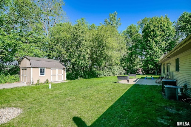15207 N 7th St, Chillicothe, IL 61523 - view of grassy yard featuring a storage unit, an outdoor structure, a patio area, and central air condition unit