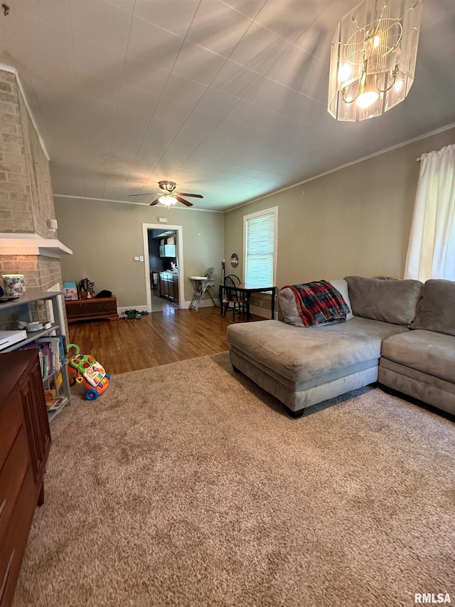 411 W Jefferson St, Macomb, IL 61455 - living room featuring a ceiling fan, wood finished floors, a chandelier, crown molding, and a brick fireplace