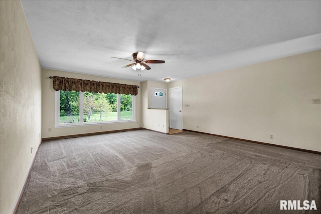 carpeted empty room with ceiling fan and baseboards