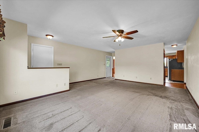 unfurnished living room with ceiling fan, carpet floors, and baseboards