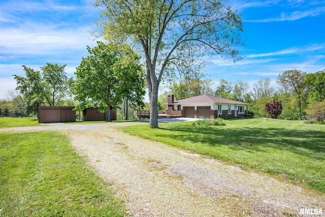 ranch-style house with driveway, a front lawn, a garage, and a chimney