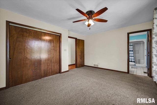 unfurnished bedroom with baseboards, carpet, a closet, ensuite bathroom, and a ceiling fan