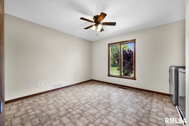 spare room with brick patterned flooring, washer and clothes dryer, baseboards, and a ceiling fan