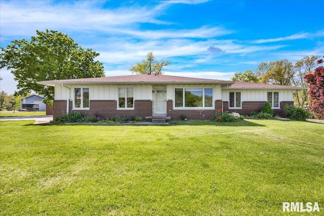 ranch-style house with board and batten siding, brick siding, and a front yard